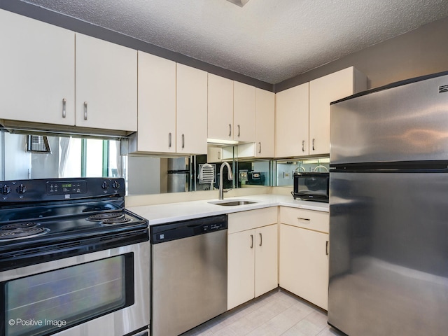 kitchen featuring appliances with stainless steel finishes, a textured ceiling, and sink