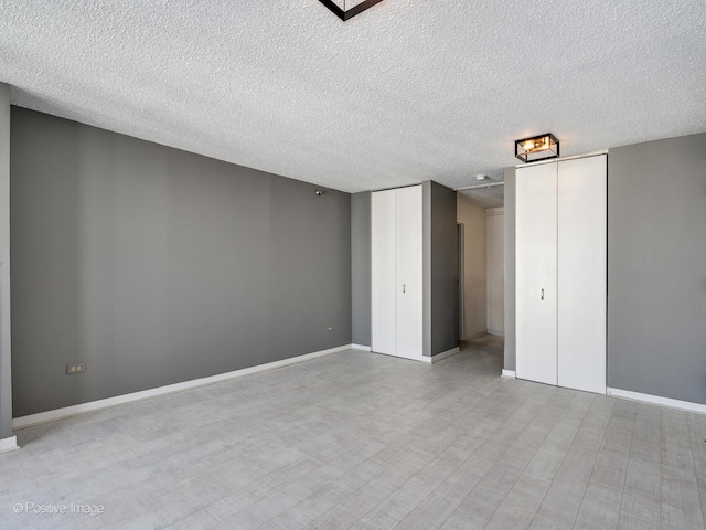 unfurnished bedroom featuring a textured ceiling and light hardwood / wood-style flooring