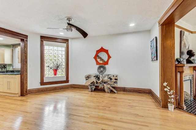 interior space featuring light hardwood / wood-style floors, a textured ceiling, and ceiling fan