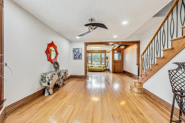 foyer with a textured ceiling, wood-type flooring, and ceiling fan