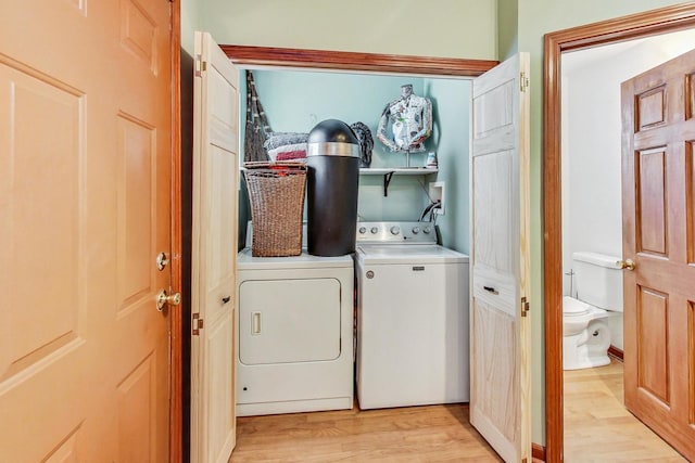 washroom with washing machine and dryer and light wood-type flooring