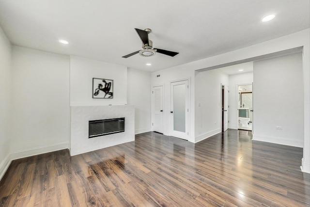 unfurnished living room with ceiling fan, a premium fireplace, and dark hardwood / wood-style flooring