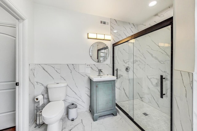 bathroom featuring vanity, toilet, tile walls, and a shower with door