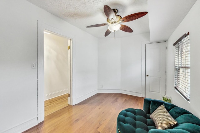 unfurnished room with light hardwood / wood-style floors, a textured ceiling, and ceiling fan