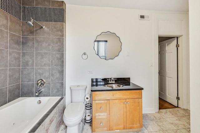 full bathroom featuring toilet, tiled shower / bath, and vanity