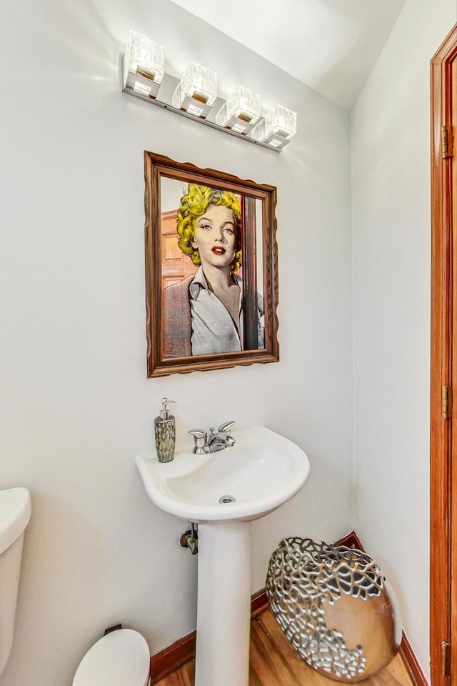 bathroom with hardwood / wood-style floors and toilet