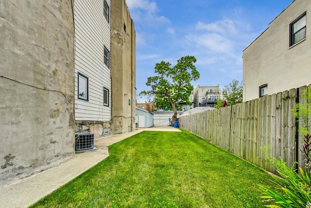 view of yard featuring central AC and a garage