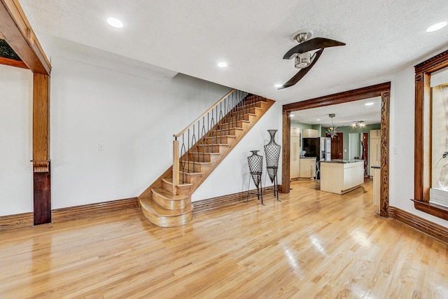 unfurnished living room featuring a textured ceiling and light hardwood / wood-style flooring