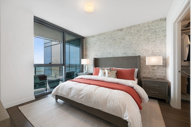 bedroom with dark hardwood / wood-style flooring and a wall of windows