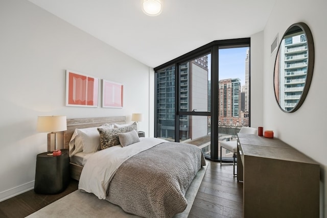 bedroom featuring dark hardwood / wood-style flooring, floor to ceiling windows, and vaulted ceiling