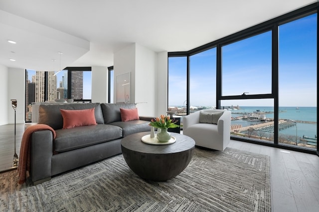 living room with a water view, hardwood / wood-style floors, and floor to ceiling windows