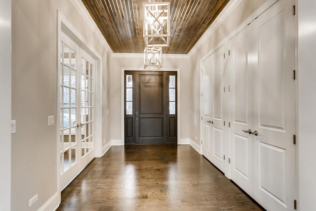 entrance foyer featuring french doors, wood ceiling, dark hardwood / wood-style floors, ornamental molding, and an inviting chandelier