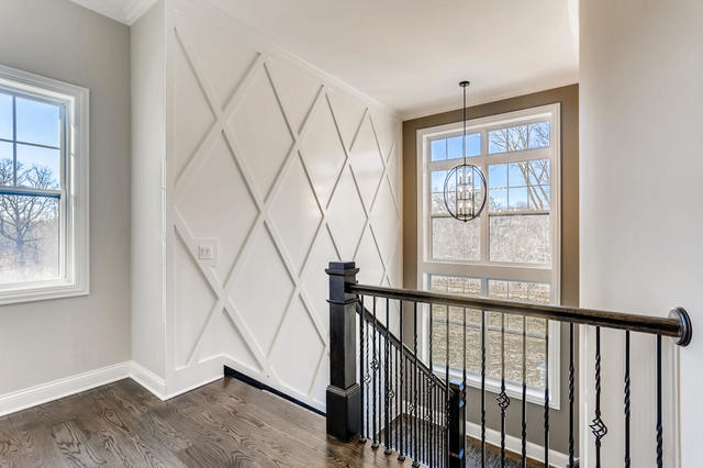 2 Alexandra Dr, Mettawa, IL 60048 - staircase featuring a chandelier, baseboards, a decorative wall, plenty of natural light, and wood finished floors