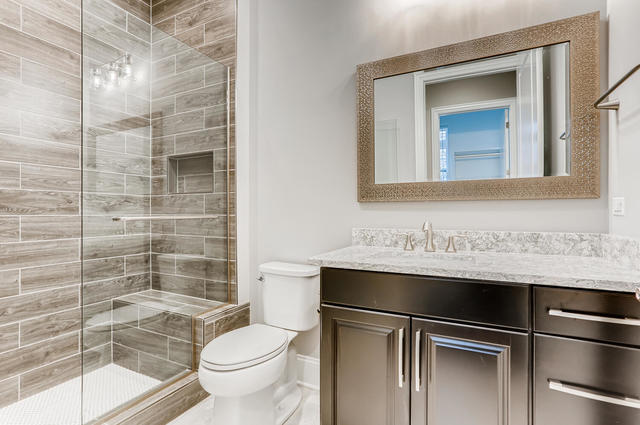 bathroom with vanity, toilet, and an enclosed shower