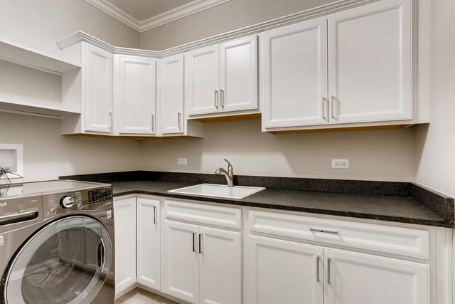 washroom with sink, washer / clothes dryer, cabinets, and ornamental molding