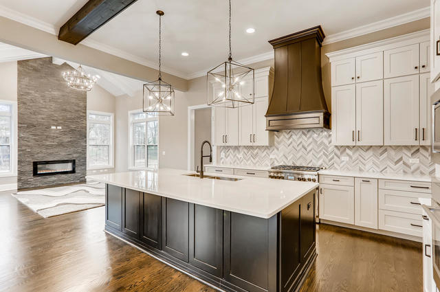 kitchen featuring pendant lighting, sink, custom exhaust hood, and a kitchen island with sink