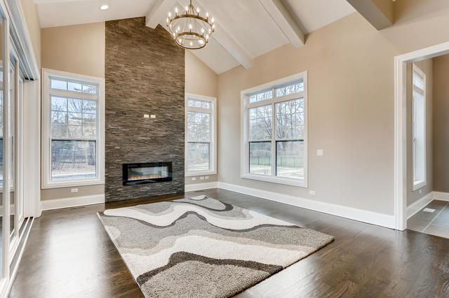 living room with beam ceiling, a healthy amount of sunlight, and dark wood-type flooring