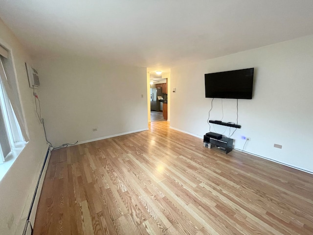 unfurnished living room featuring light hardwood / wood-style flooring and baseboard heating