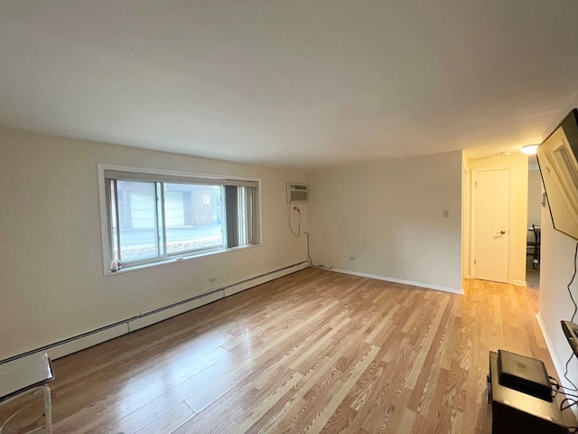 unfurnished living room with light hardwood / wood-style floors, a baseboard heating unit, and a wall mounted air conditioner