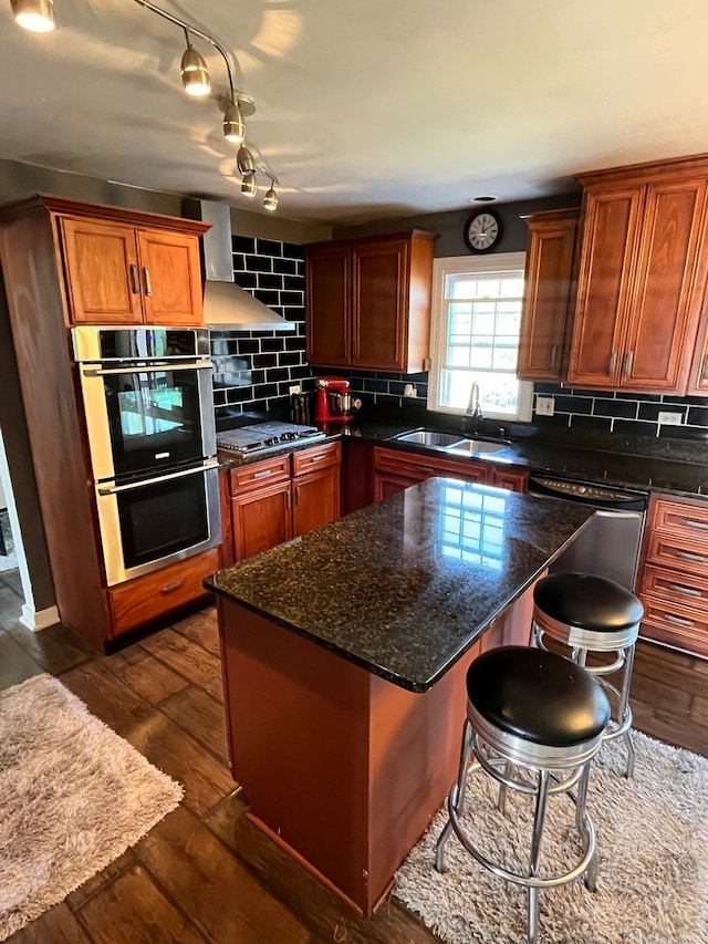 kitchen with decorative backsplash, wall chimney range hood, stainless steel appliances, sink, and dark hardwood / wood-style flooring