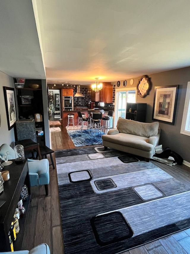 living room featuring a notable chandelier and dark hardwood / wood-style flooring