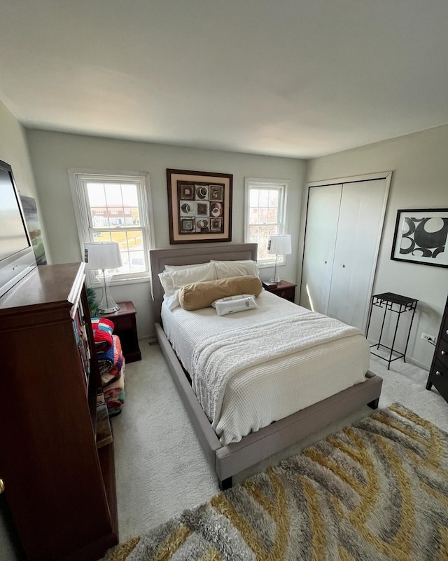 bedroom featuring multiple windows, a closet, and light colored carpet