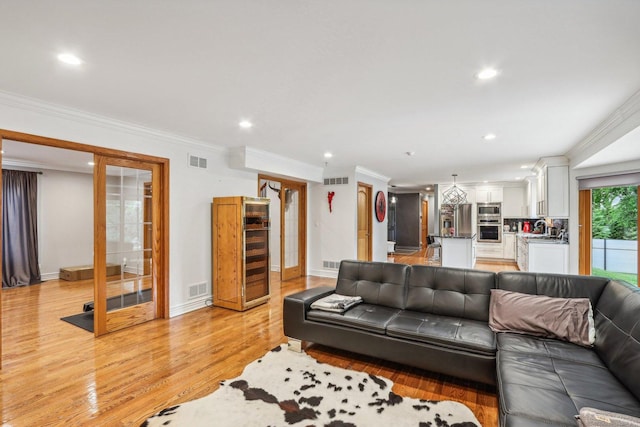 living room with light hardwood / wood-style flooring and ornamental molding