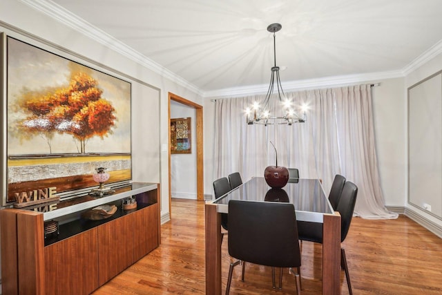 dining space featuring crown molding, a notable chandelier, and light wood-type flooring