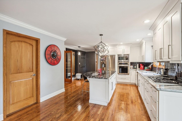 kitchen featuring dark stone countertops, a center island, white cabinets, and appliances with stainless steel finishes