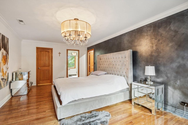 bedroom featuring hardwood / wood-style floors, a chandelier, and ornamental molding