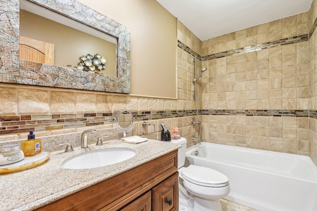 full bathroom featuring tile walls, vanity, tiled shower / bath combo, and toilet