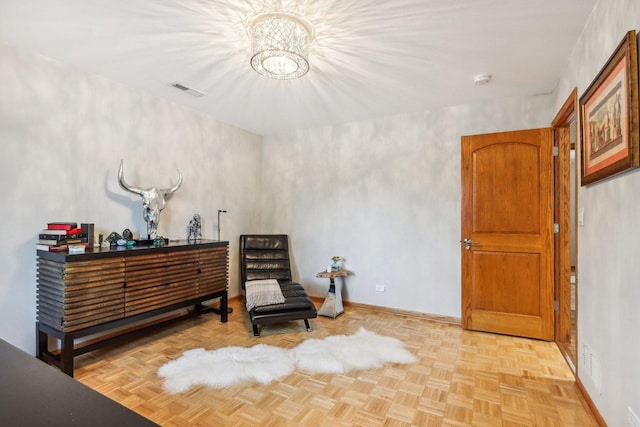 sitting room featuring light parquet flooring and a notable chandelier