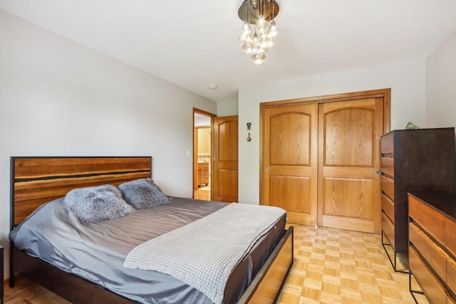 bedroom featuring an inviting chandelier and light parquet floors