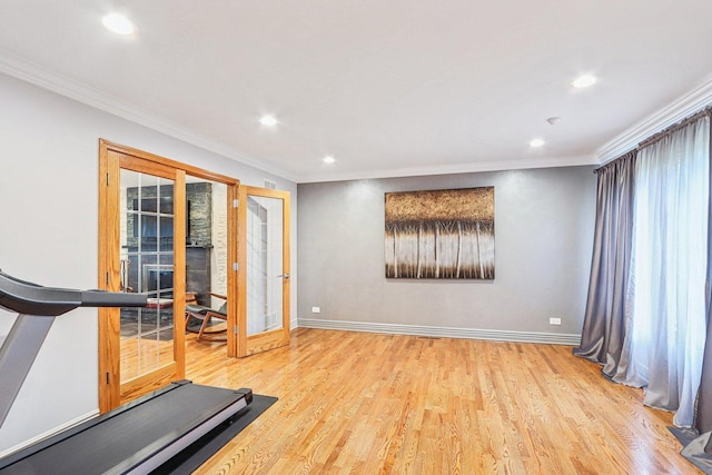 workout area featuring ornamental molding, light hardwood / wood-style flooring, and french doors