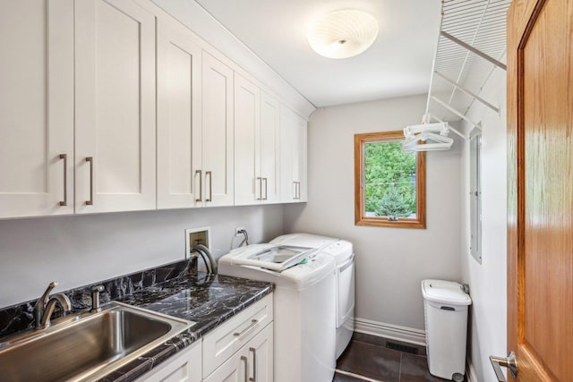 washroom featuring dark tile patterned flooring, cabinets, separate washer and dryer, and sink