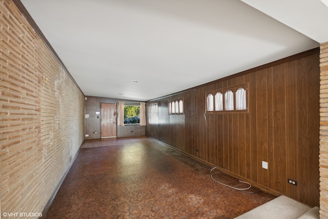 hallway featuring wooden walls and brick wall