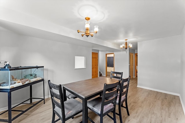 dining room featuring a notable chandelier and light wood-type flooring