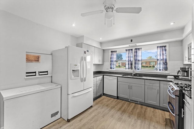 kitchen featuring gray cabinetry, decorative backsplash, ceiling fan, and white appliances