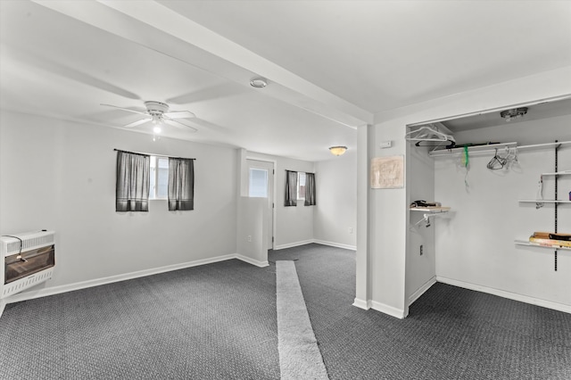 basement featuring heating unit, ceiling fan, and dark colored carpet