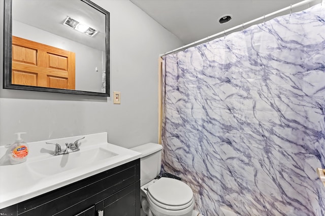 bathroom with curtained shower, vanity, and toilet