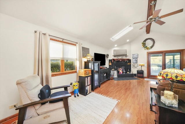 living room featuring light hardwood / wood-style flooring, lofted ceiling, and ceiling fan