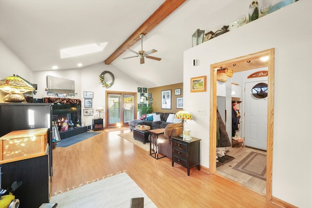 living room with vaulted ceiling with beams, light hardwood / wood-style flooring, and ceiling fan