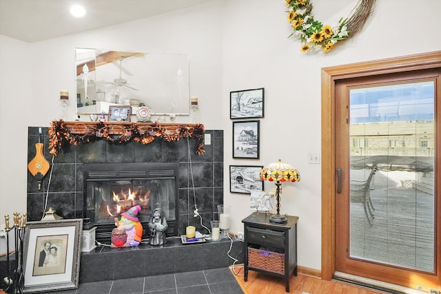 details with hardwood / wood-style floors, a tile fireplace, and ceiling fan