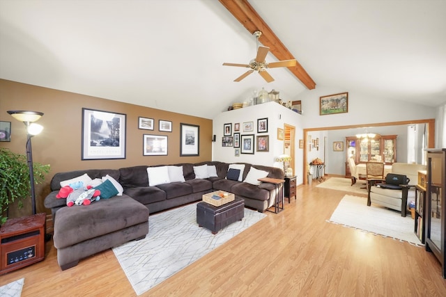 living room with beamed ceiling, ceiling fan with notable chandelier, high vaulted ceiling, and light wood-type flooring