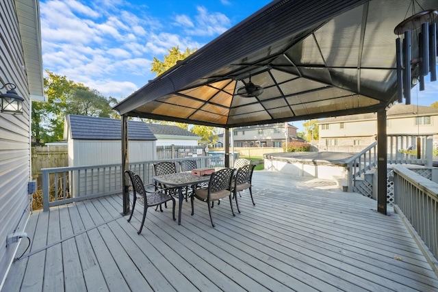 deck with a shed, a gazebo, and ceiling fan