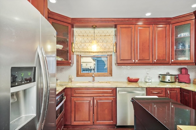 kitchen featuring stainless steel appliances, tasteful backsplash, sink, and pendant lighting