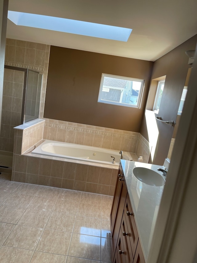 bathroom featuring vanity, tile patterned floors, a skylight, and plus walk in shower