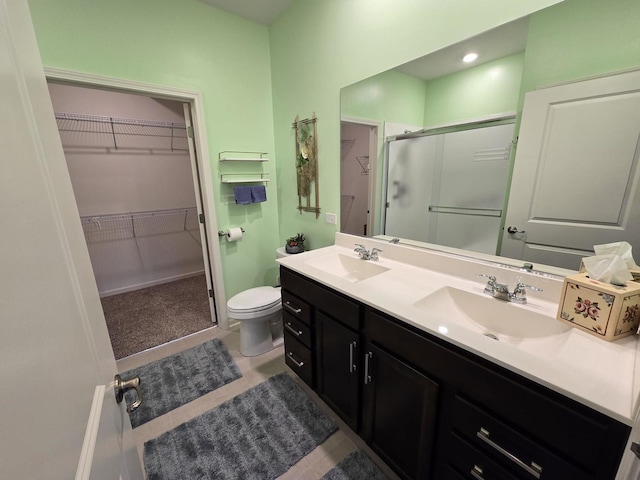 bathroom with vanity, tile patterned flooring, toilet, and walk in shower