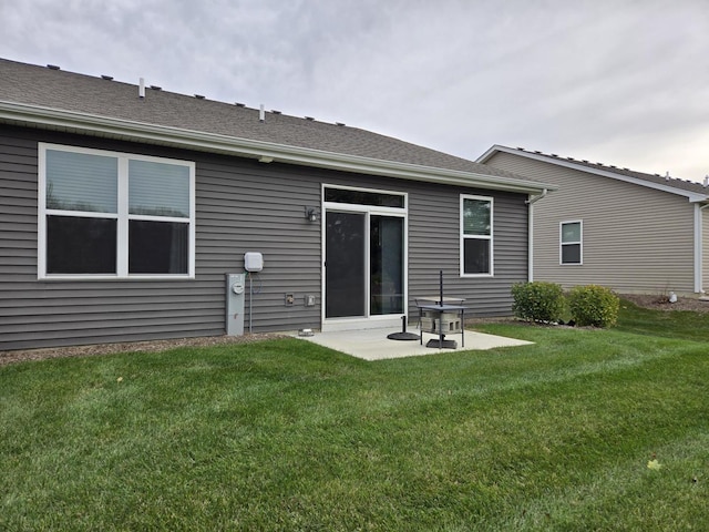 rear view of property featuring a yard and a patio