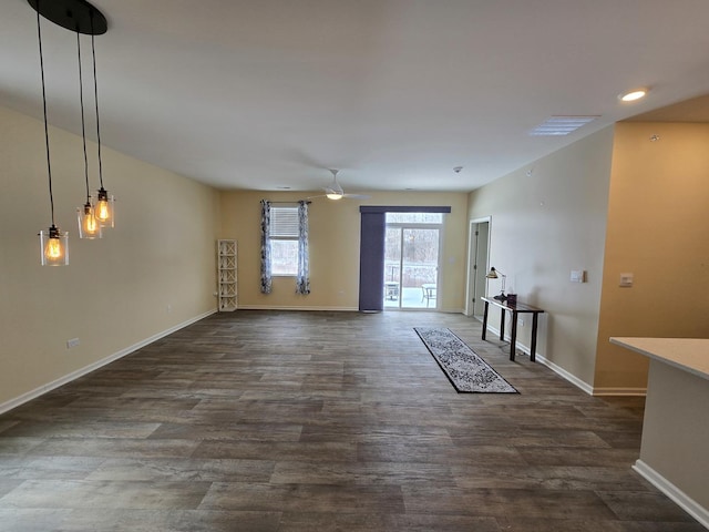 unfurnished living room with dark hardwood / wood-style flooring and ceiling fan